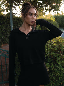 A soft black pullover made with 100% organic cotton and a polo style collar with a three button closure