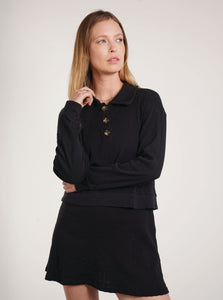 A soft black pullover made with 100% organic cotton and a polo style collar with a three button closure